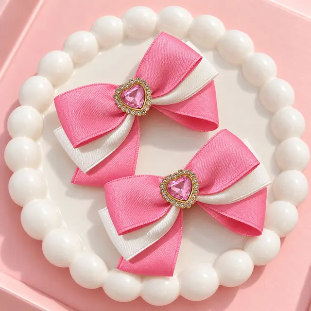 Pink Luxe Bow Pair: Layered pink and ivory ribbon bows with a pink heart-shaped jeweled centerpiece.